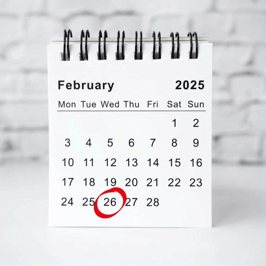 A desktop calendar shows the month of February, 2025 with the date of the 26th circled in a red marker.