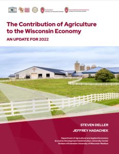 Modern dairy farm with white buildings, blue-roofed barns, grain silos, white fencing, and green pastures. Image is part of a 2022 economic report on agriculture's contribution to the Wisconsin economy.