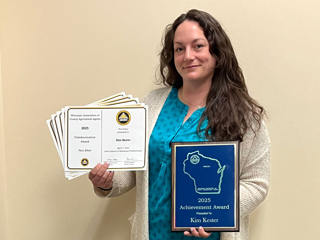 Kim Kester, Regional Livestock Educator in Grant, Green, Iowa and Lafayette Counties with her Communication and Early Career Achievement Awards.