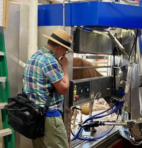 A man looking contemplatively in front of an automatic milking system.